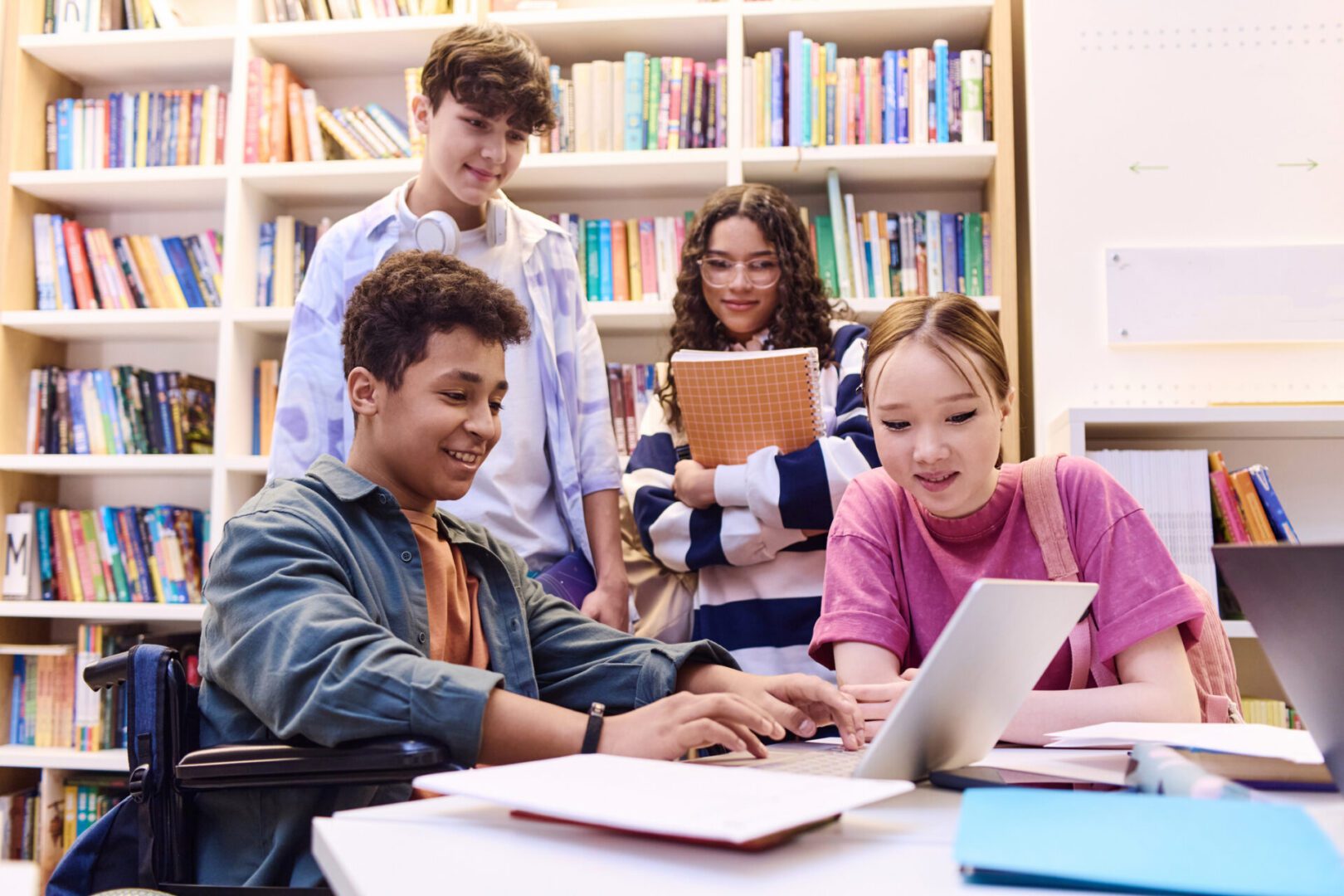 Friends studying together with bookshelves behind